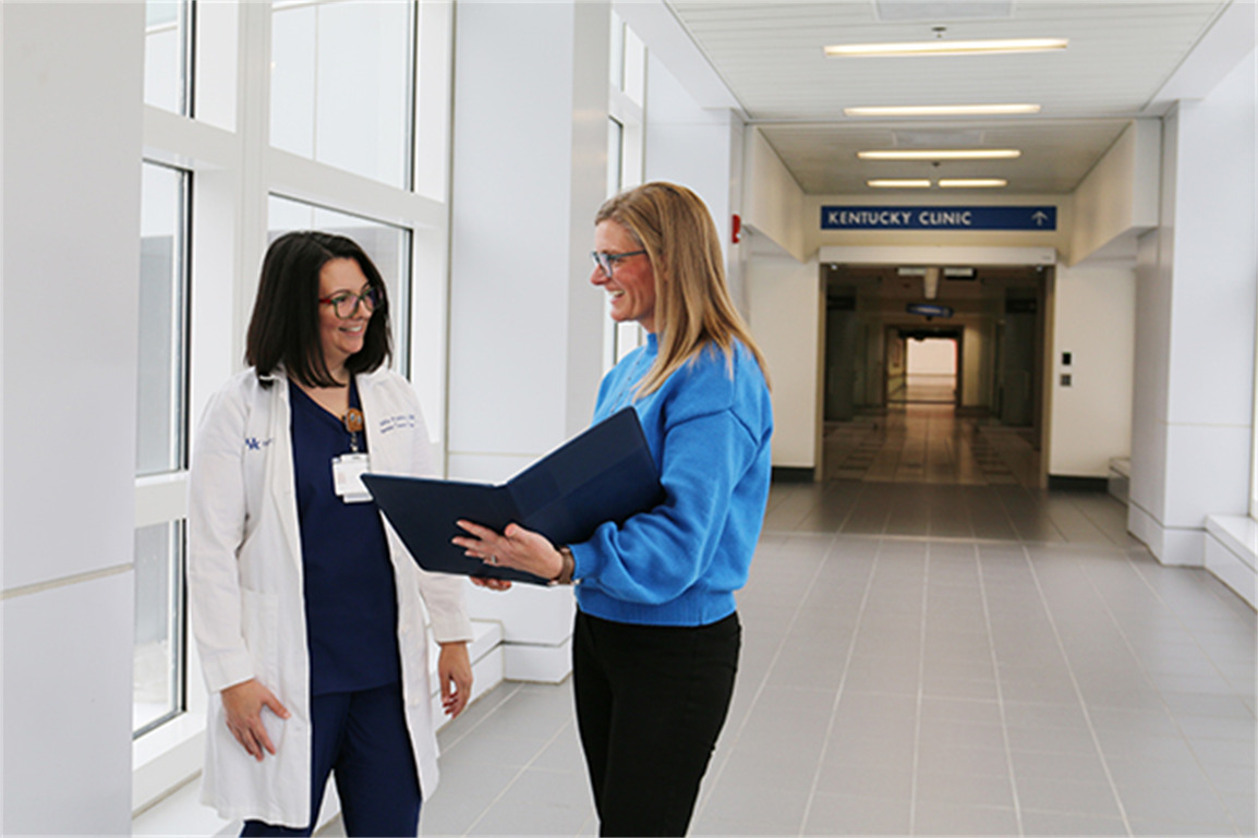 APP Gastroenterology, Erika Moffitt, left, and Ambulatory Medicine Social Worker Senior Alyssa Miller, right, discuss ways to improve patient care while walking the halls of Kentucky Clinic.