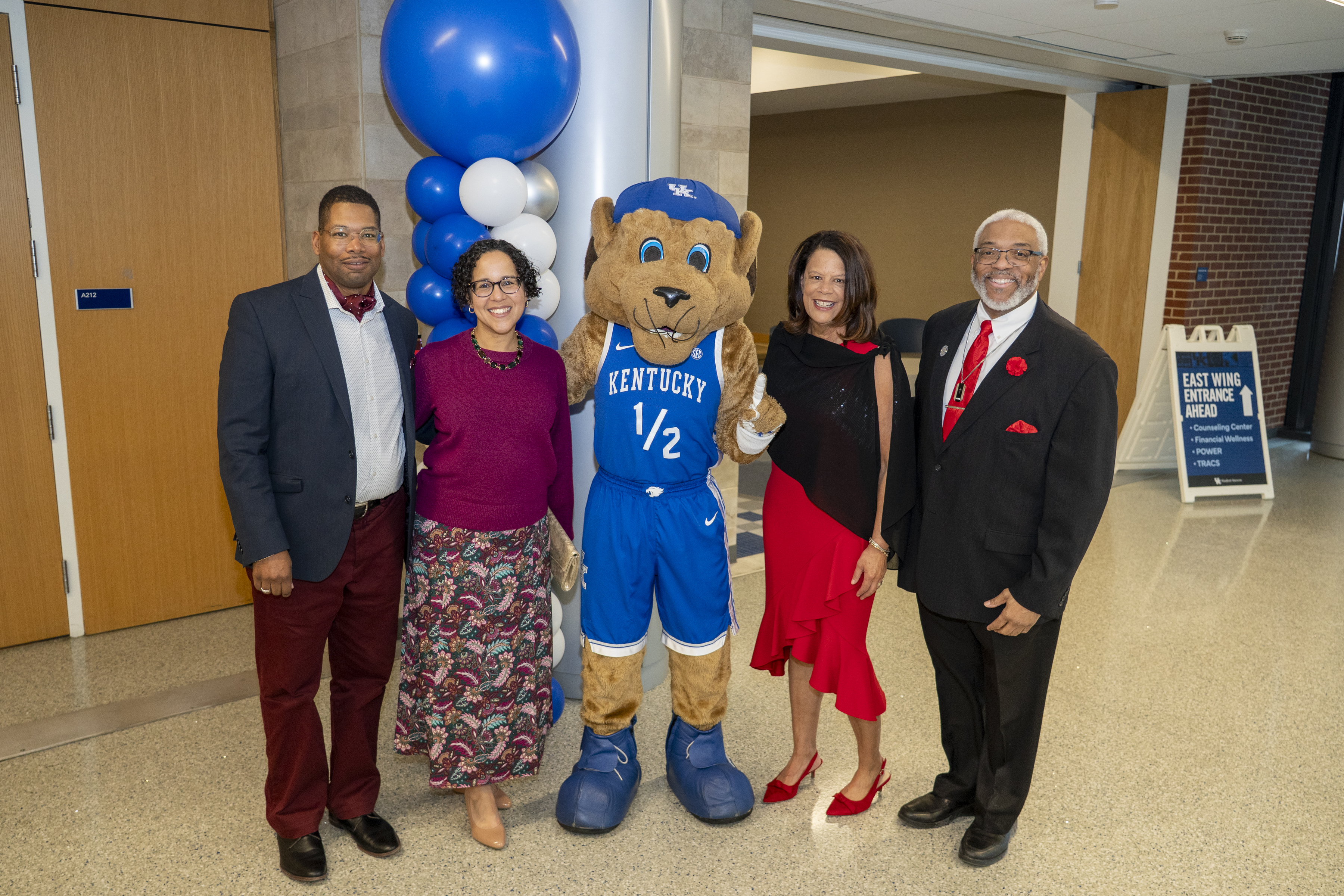 Doctor Darwin Conwell and Clinical Administrator Matt Turner pose with Scratch the wildcat and their wives