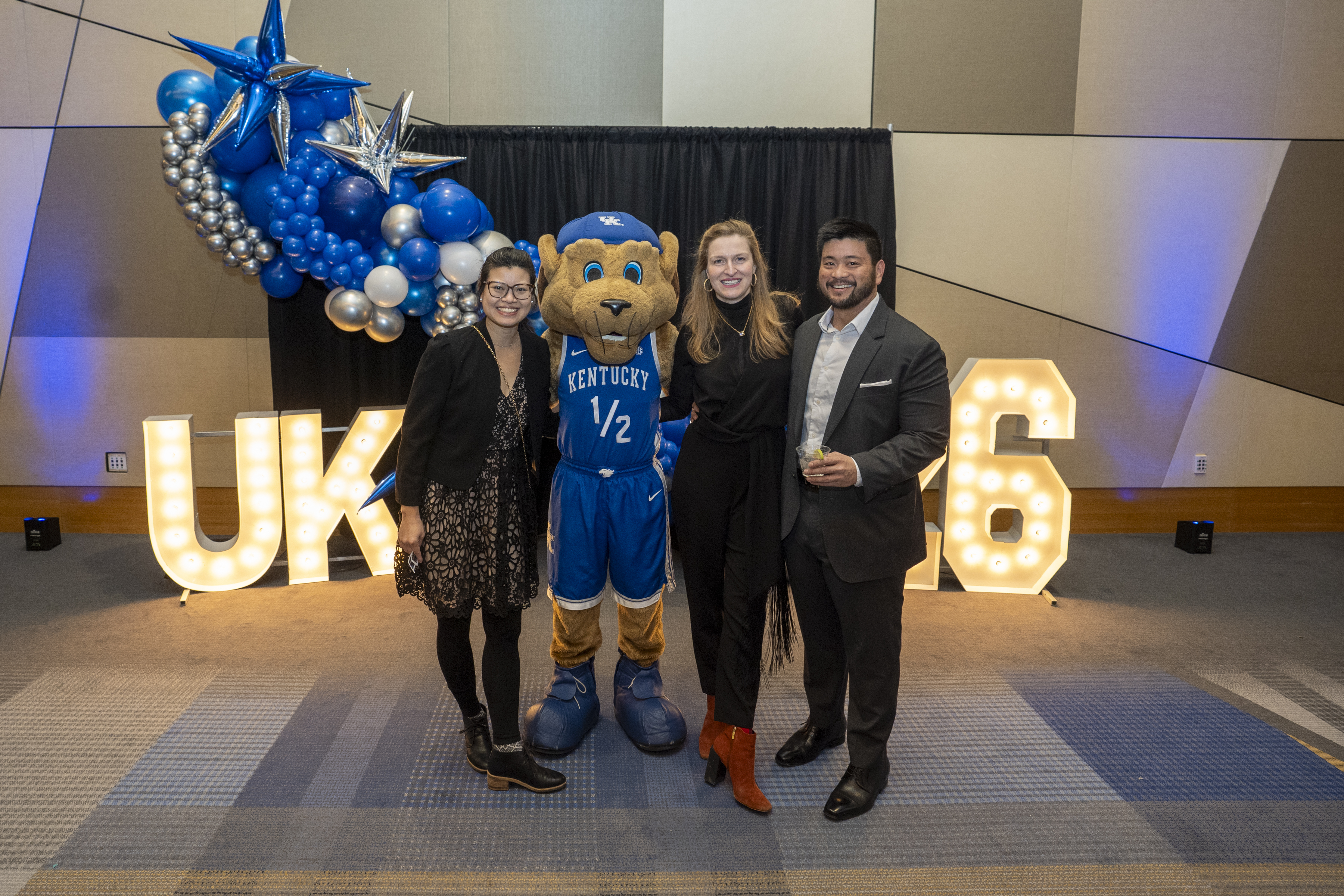 Doctor Darwin Conwell and Clinical Administrator Matt Turner pose with Scratch the wildcat and their wives