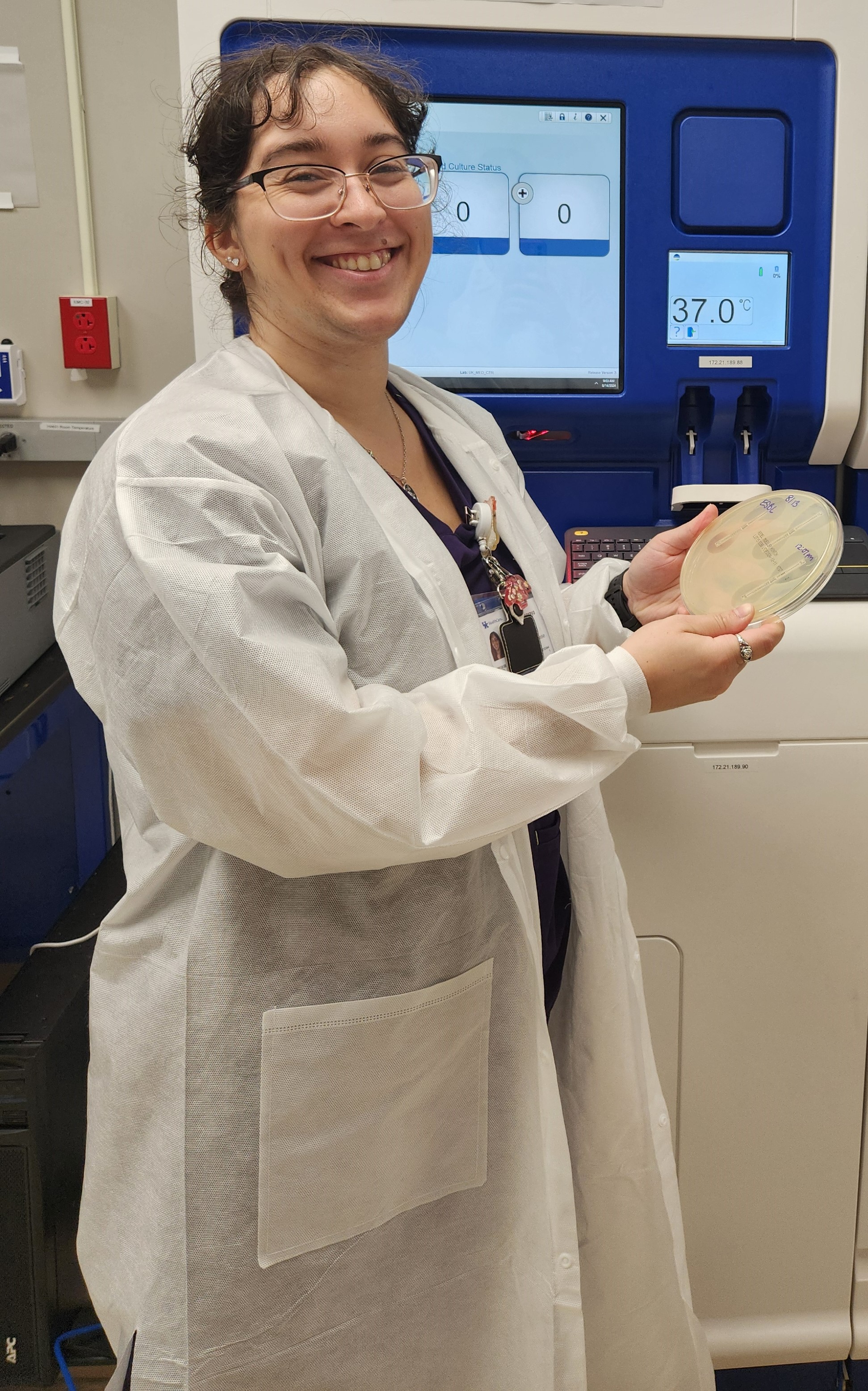 A photo of an individual working in the Jamila Lab in a white coat