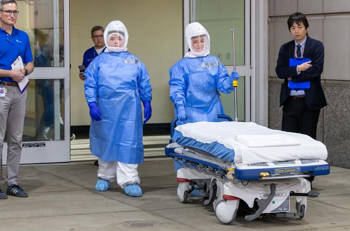 UK HealthCare Infection Prevention and Control Medical Directors Nicholas Van Sickels, far left, and Takaaki Kobyashi, far right, oversee intake of the pretend patient during the drill.