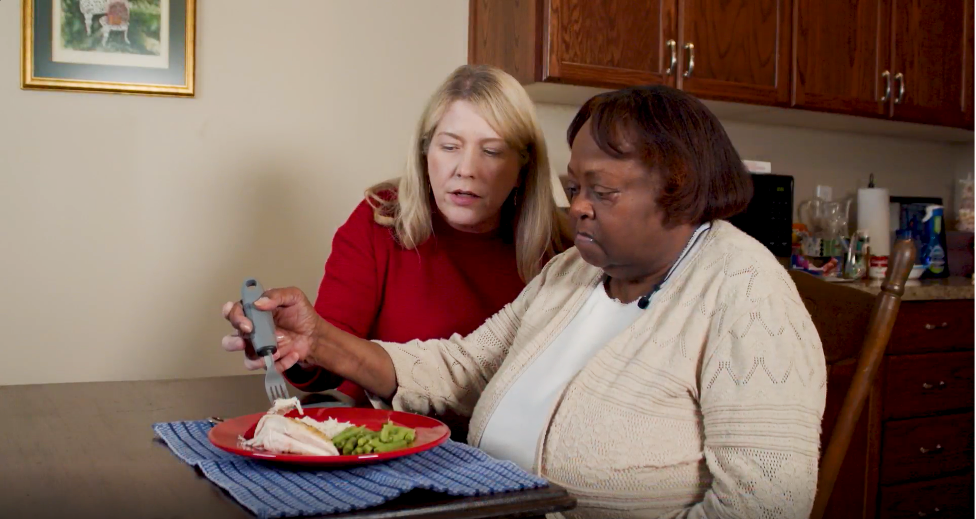 A caregiver is assisting a loved one in eating dinner. 