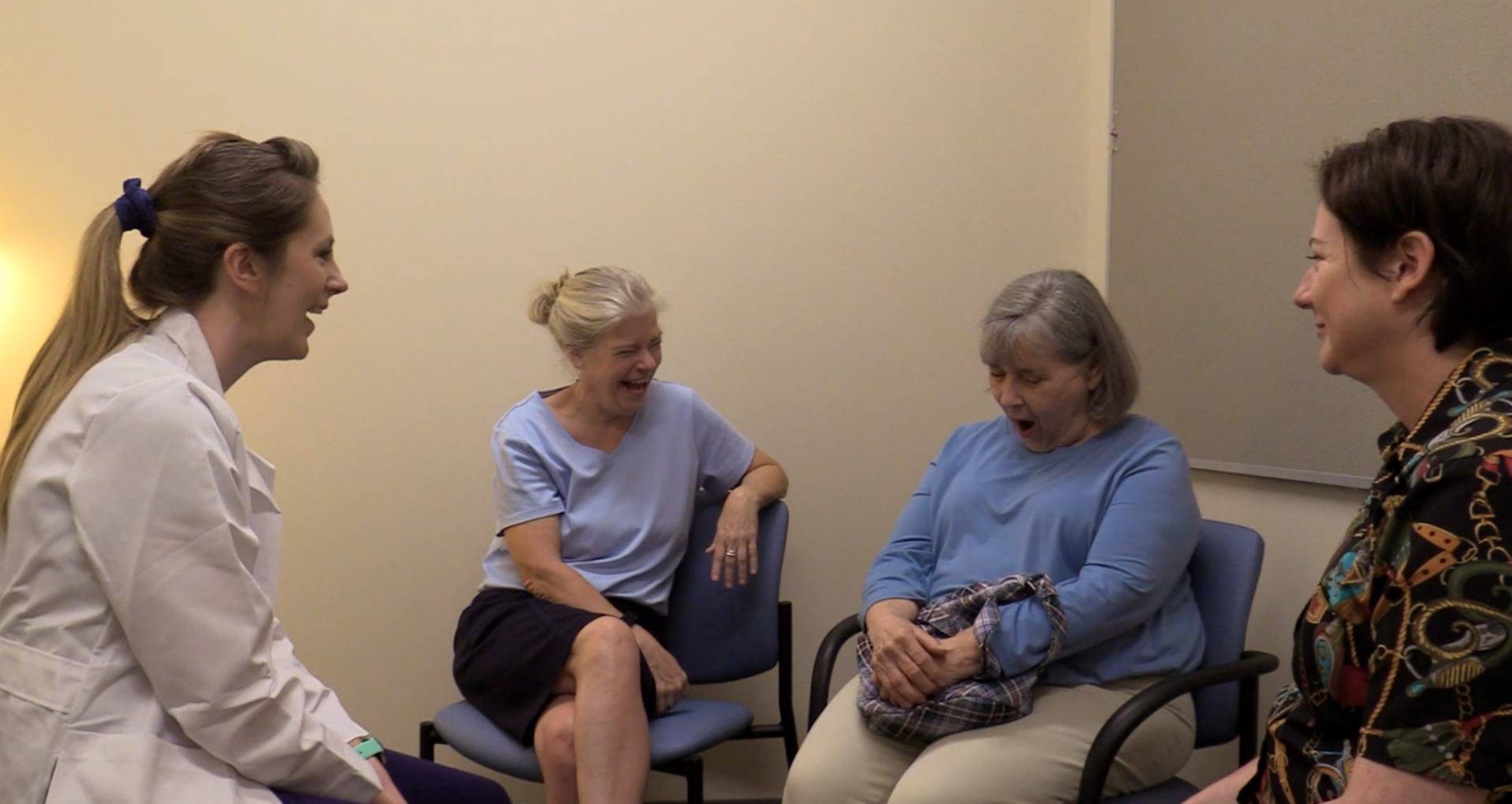 A doctor is conducting a clinic visit with a patient and her caregivers. 
