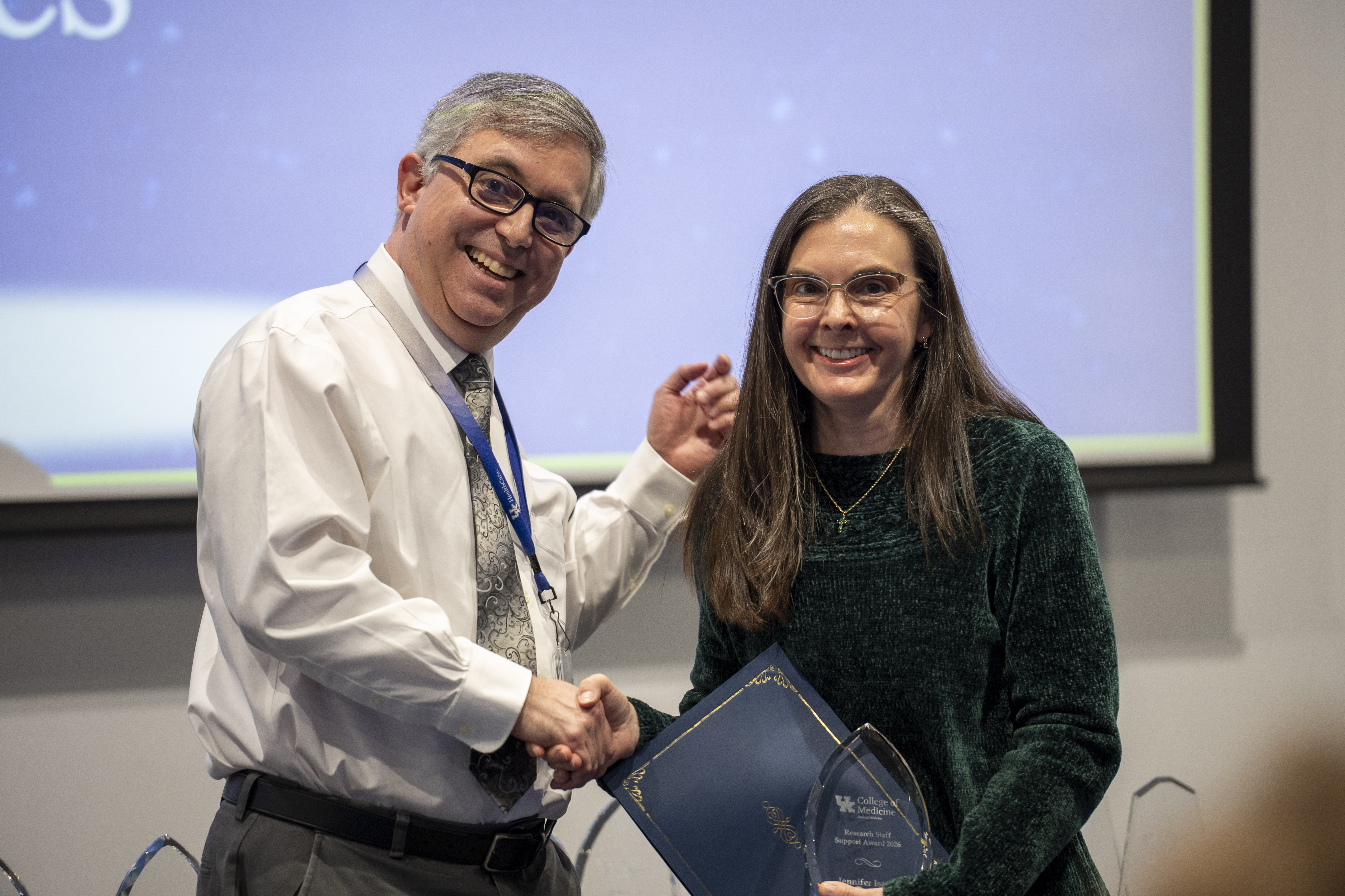 Jennifer Isaacs receives a research award from Dr. Simon Fisher
