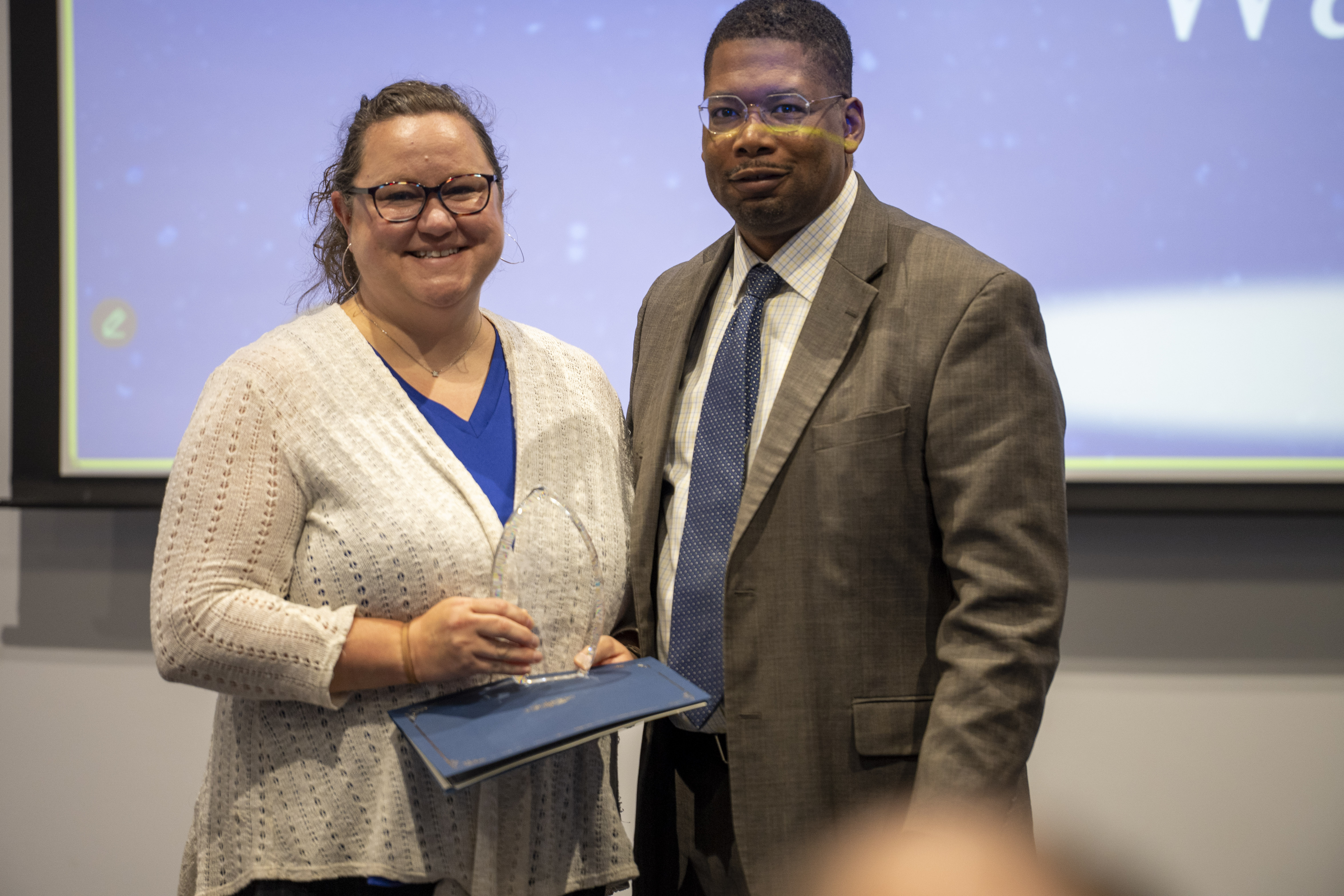 Brandi Waskul receives an award from Matt Turner