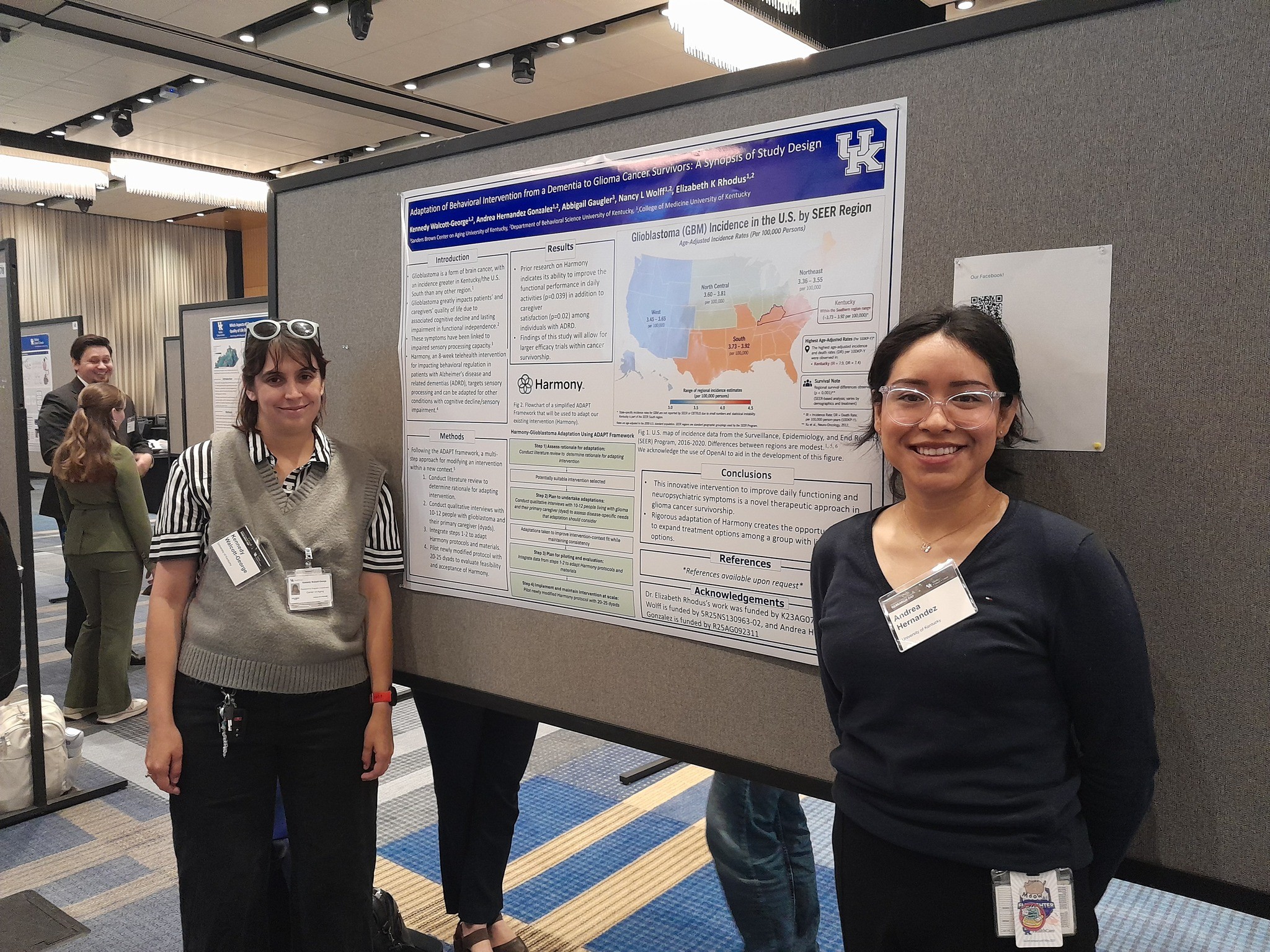 Two women standing on opposite sides of a research poster 