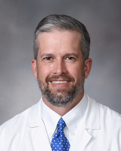 Headshot of Jonathan Webb in his white coat