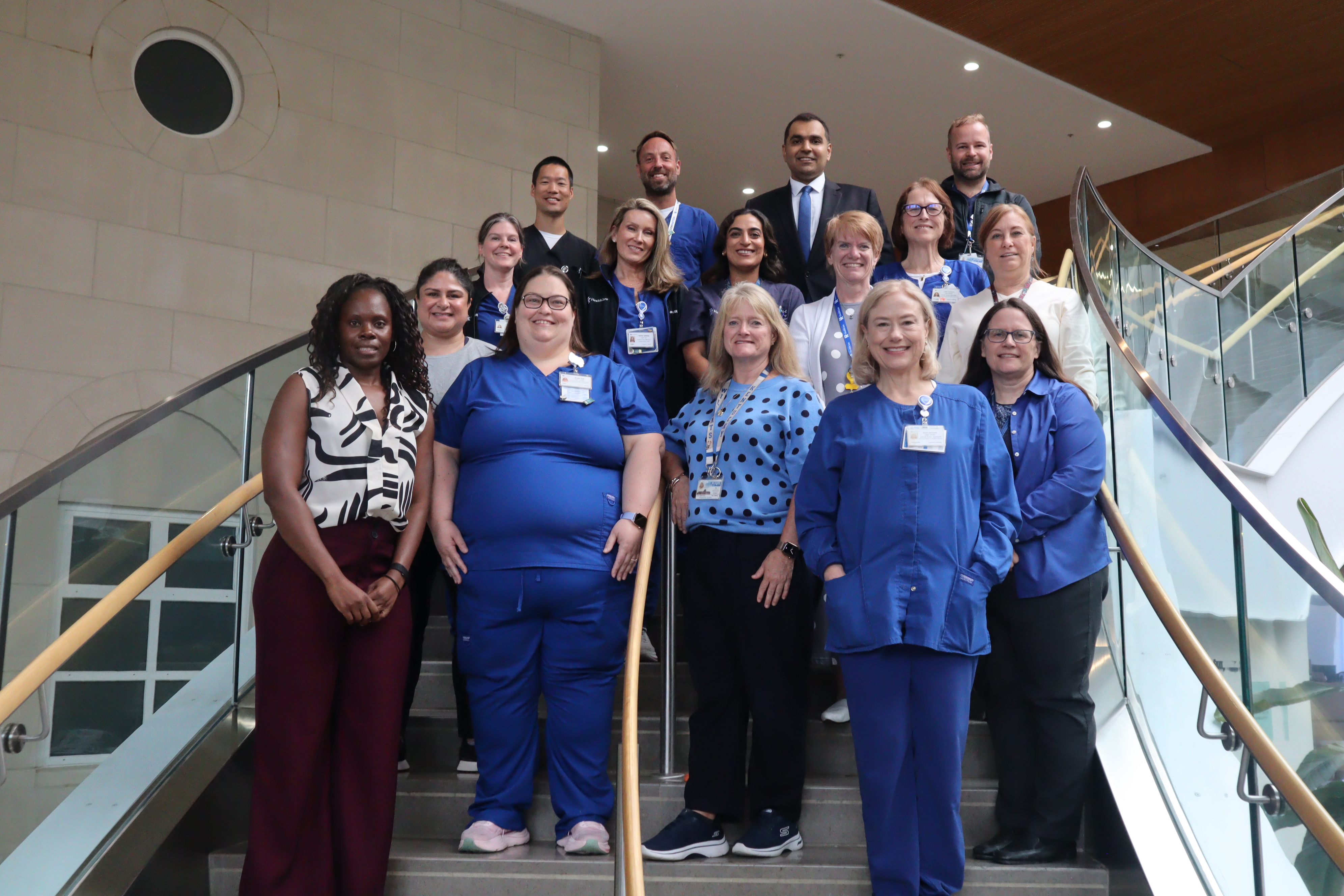 The A2F ICU liberation workgroup stand on stairs in a group, smiling