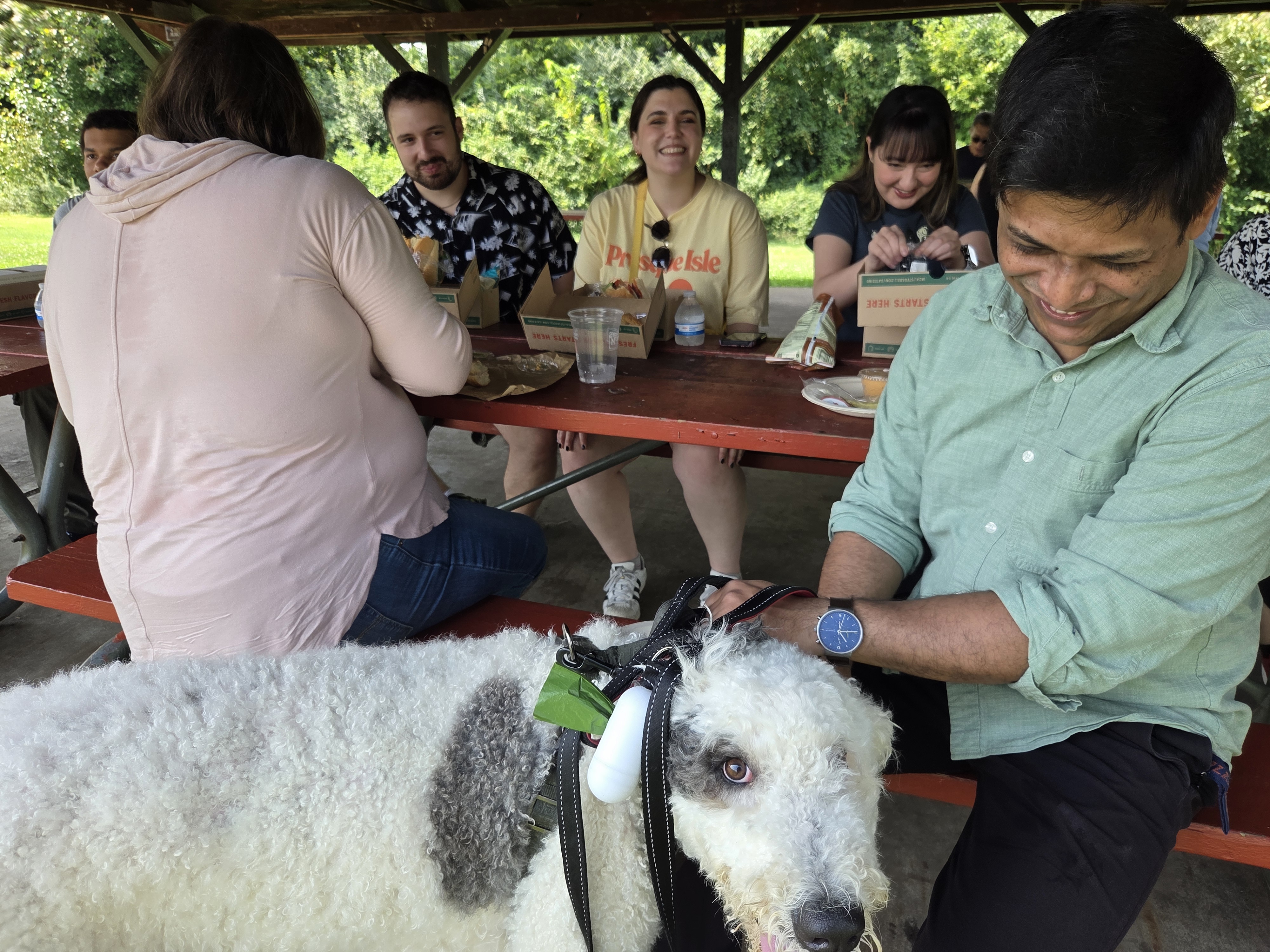 Attendees sitting at table with a black and white dog