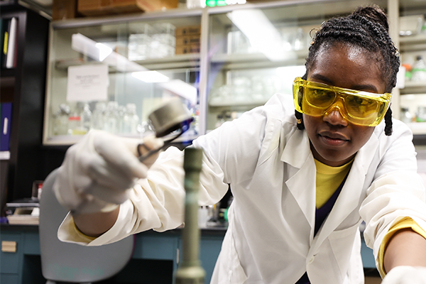Young woman wearing goggles in lab environment