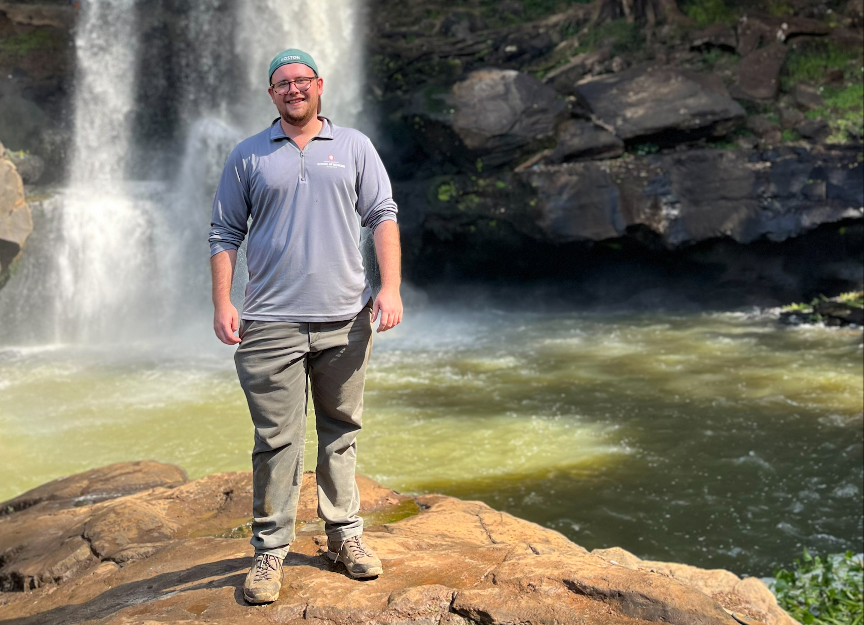 Benjamin Fischer standing in front of a waterfall.