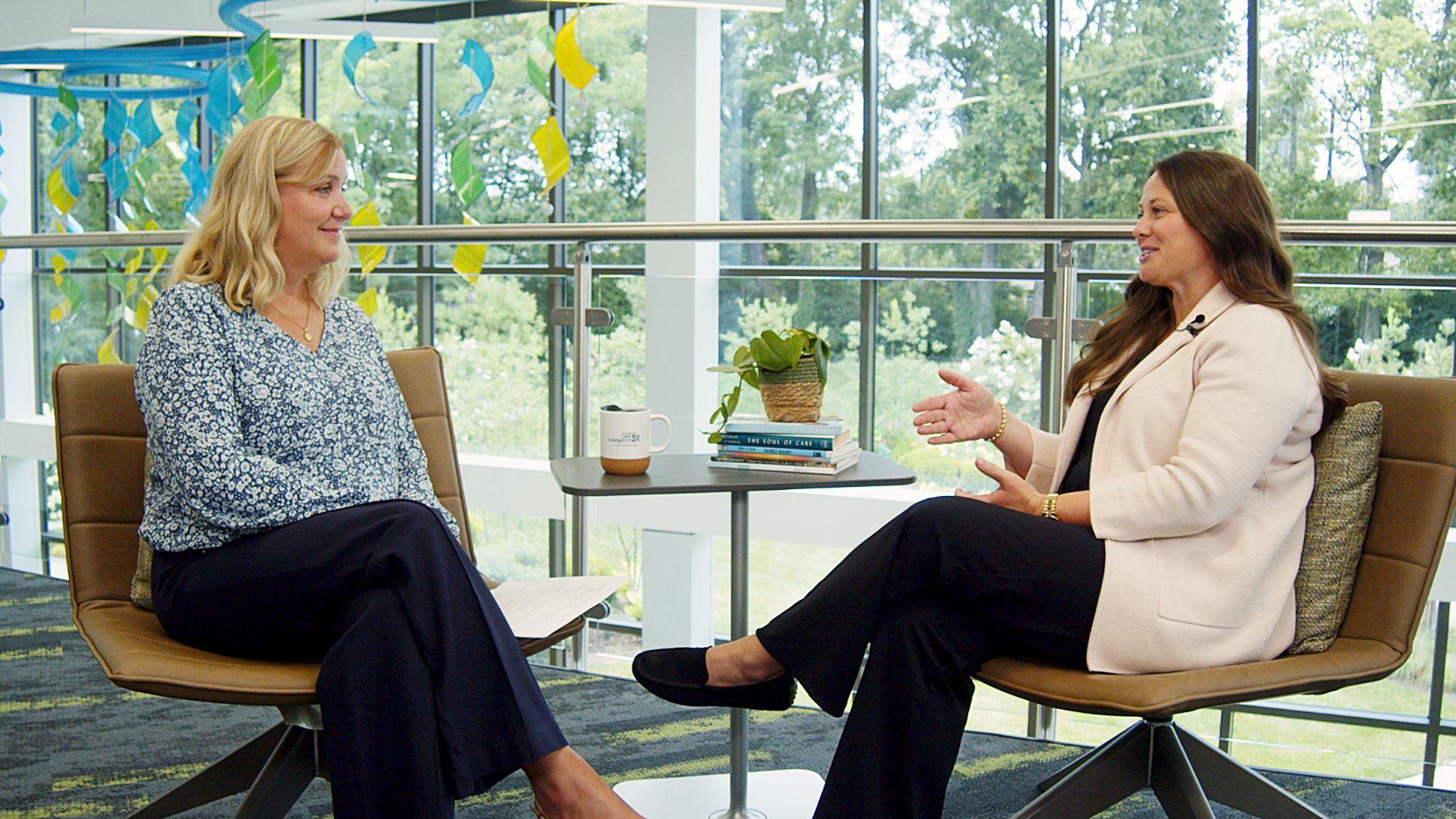 Two women sitting in chairs discussing Hospice. 