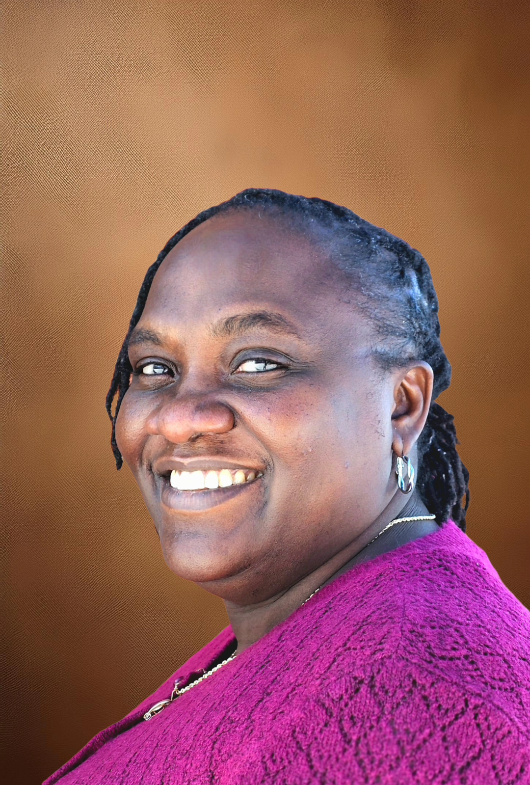 Woman with purple blouse smiling on brown background