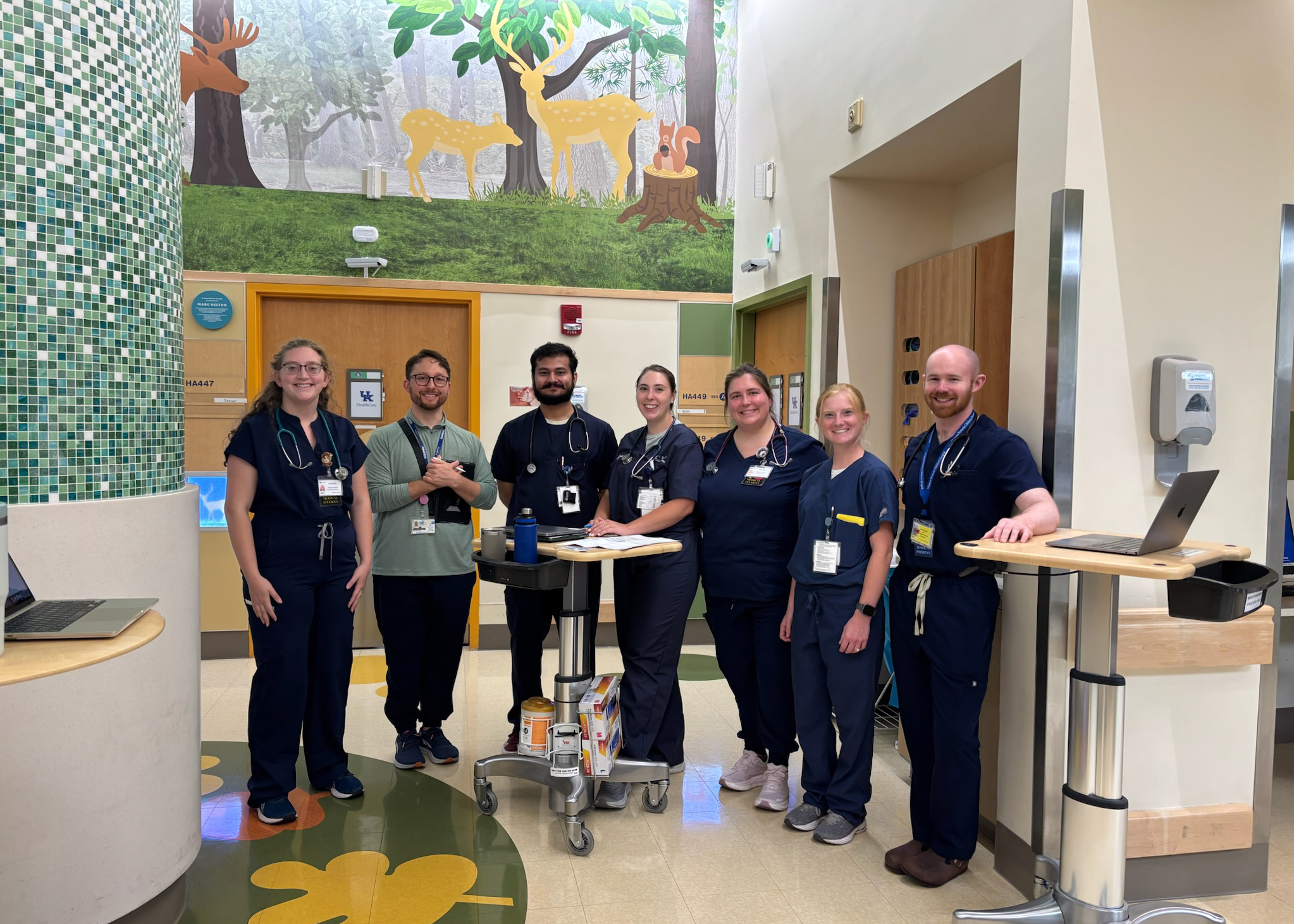 Medical professionals gathered near a mural in the children's clinic.