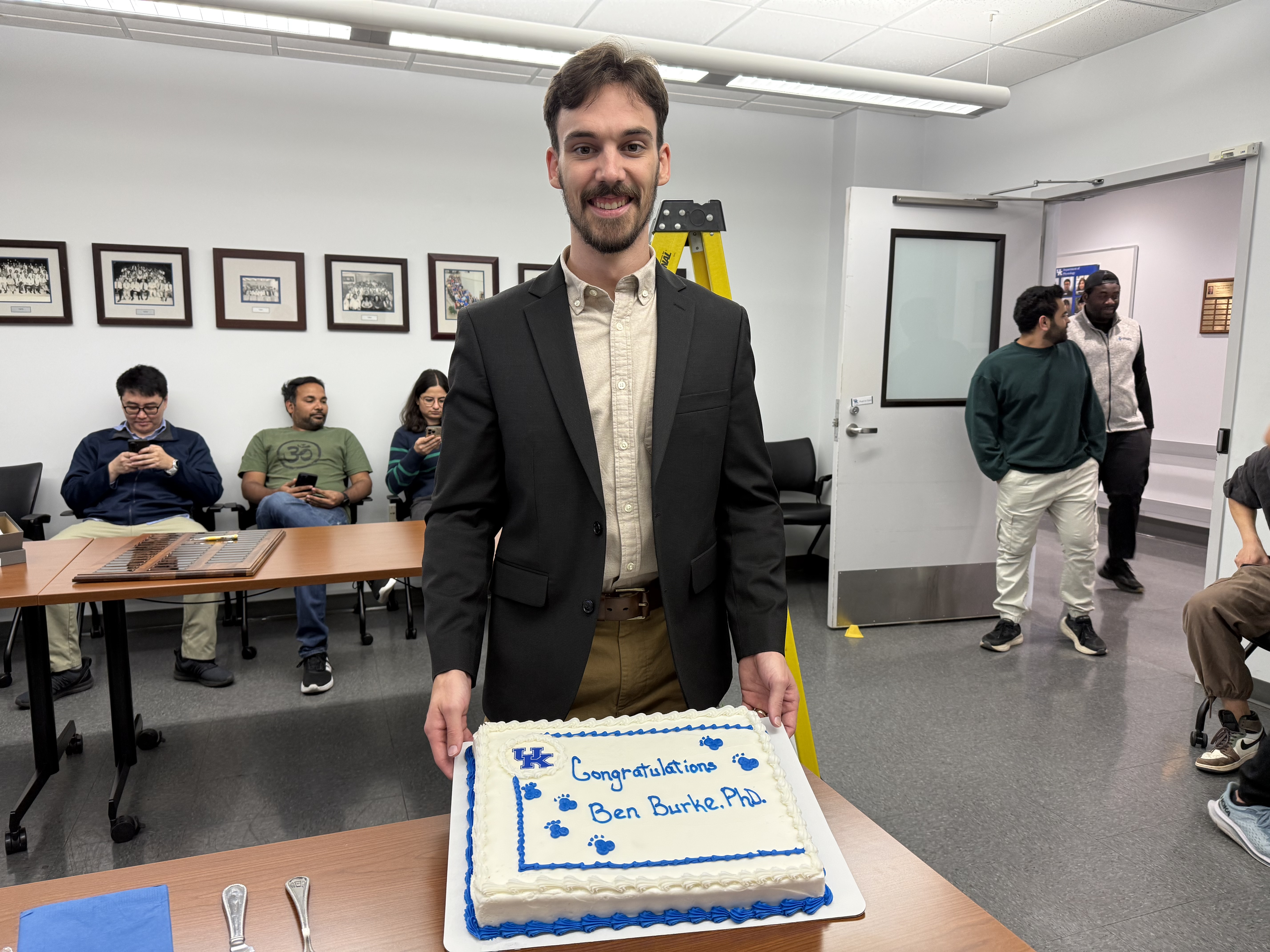 Dr. Burke poses with his congratulatory cake during his defense celebration. 