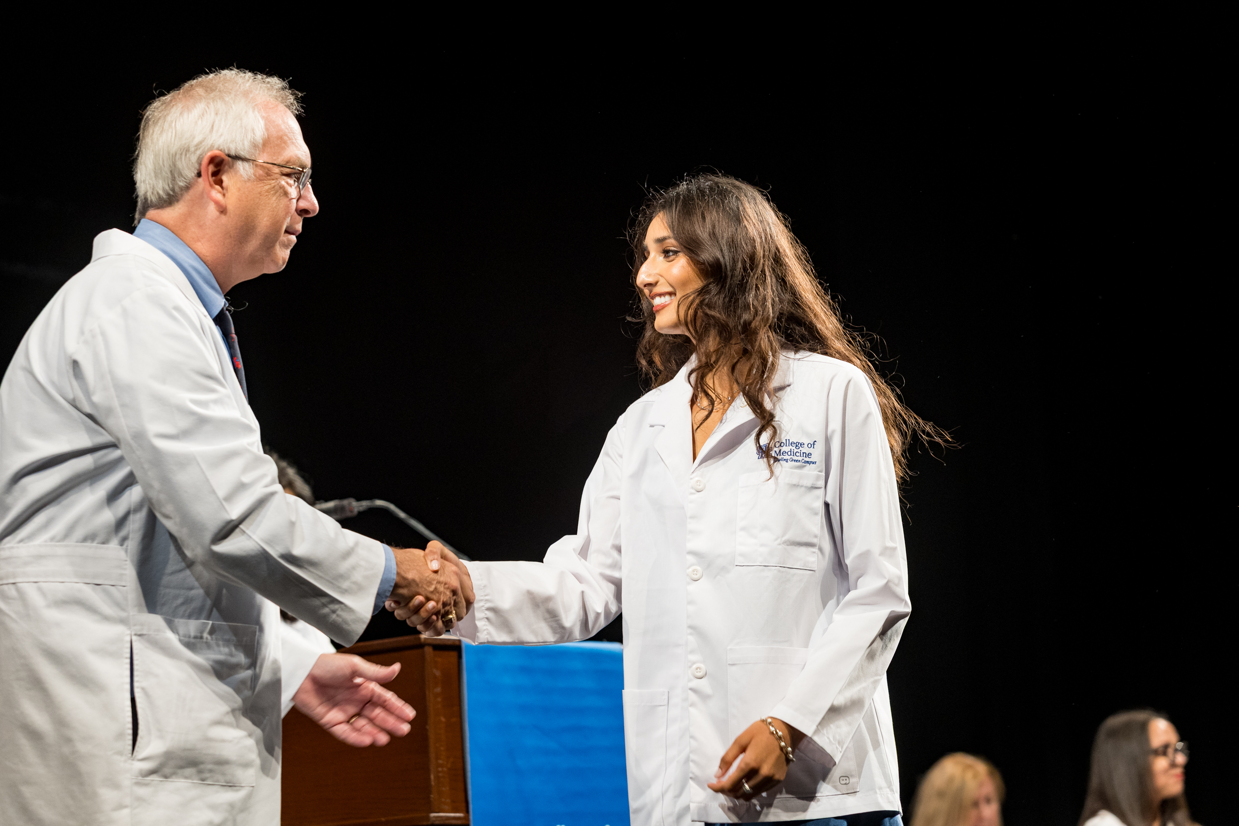 Dean Griffith shakes hand with newly coated med student