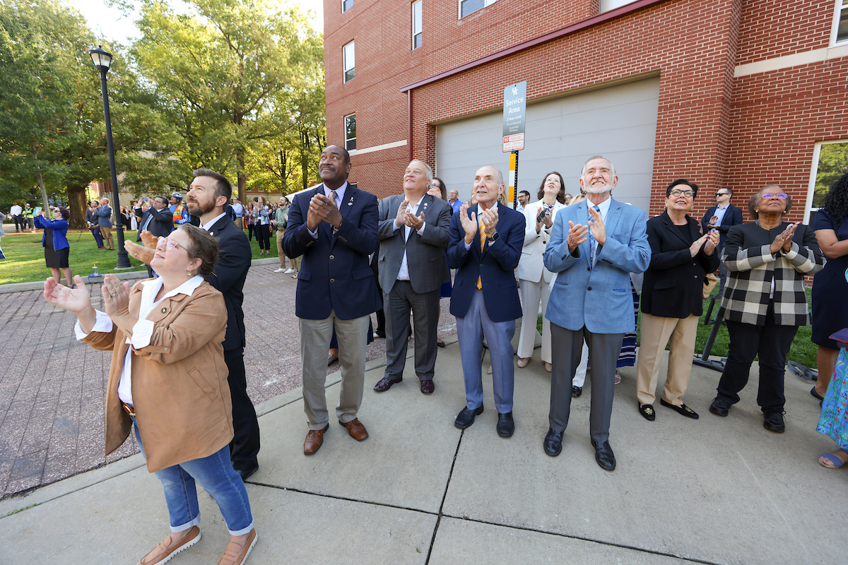 Onlookers gather to watch the beam be placed atop the structure