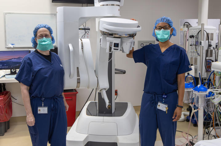 Shari Meyerson, M.D. (left) and Mansi Shah, M.D. (right) stand on either side of the Da Vinci robot