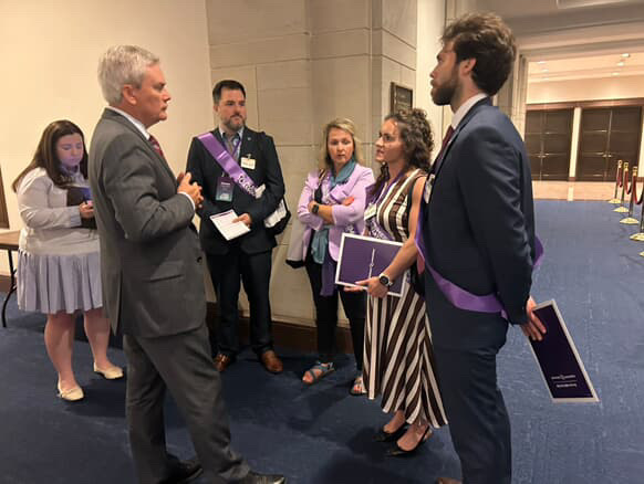 Volunteer advocates gathered in conversation outside a lawmaker's office