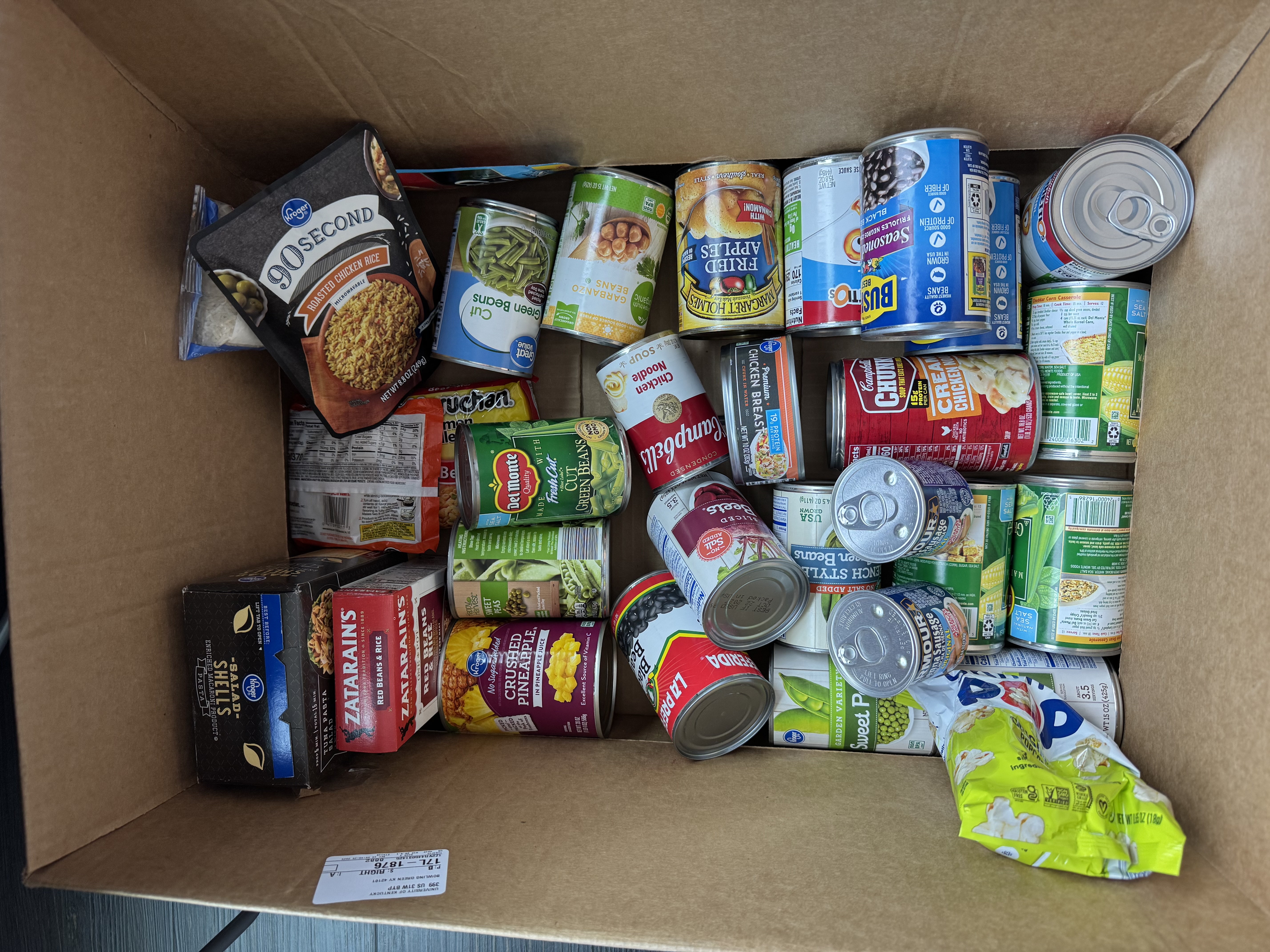 Collection of canned and other non-perishable food in a cardboard box