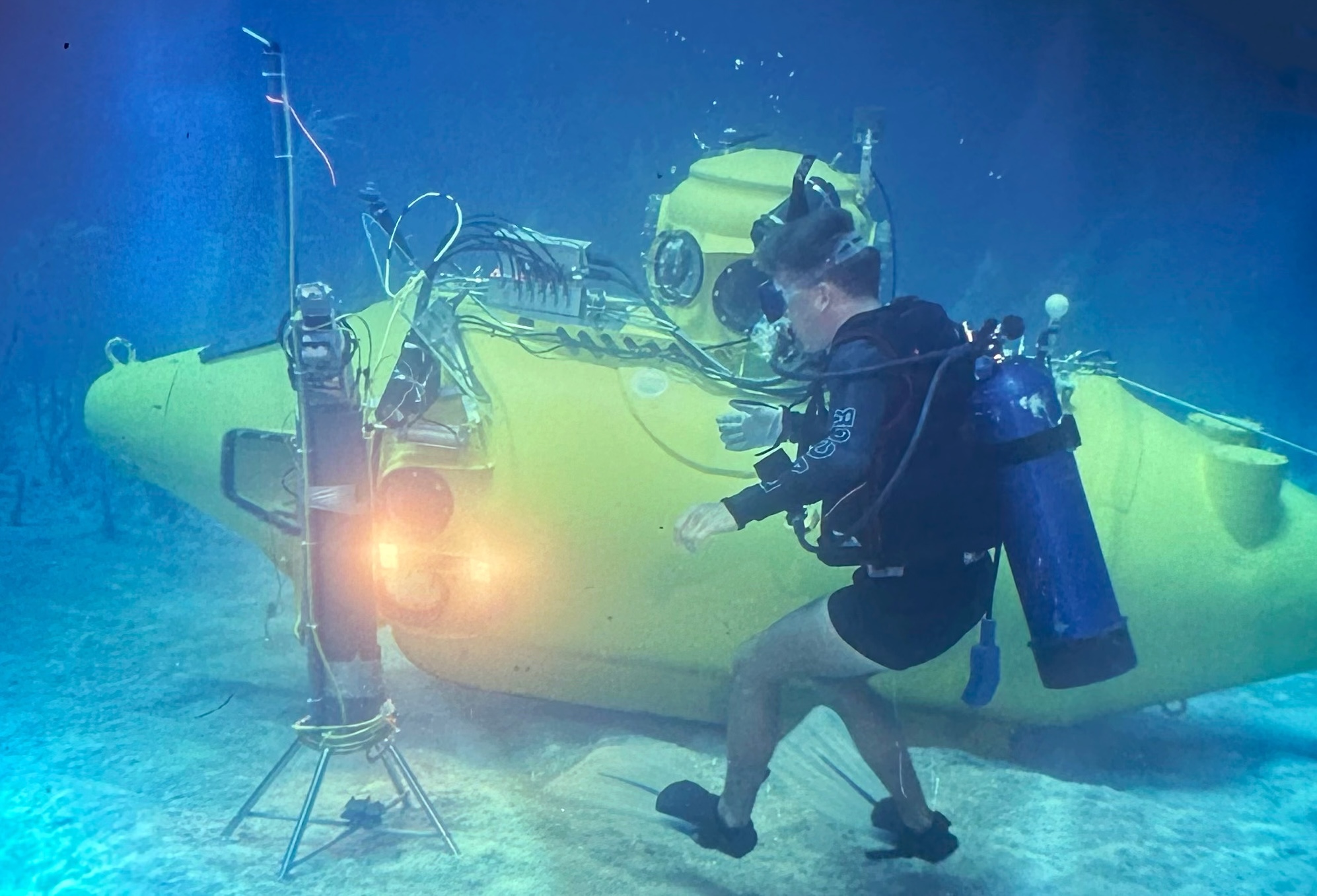 Scuba diver in clear blue ocean in front of yellow submersible | Photo provided by Dr. Gerhardt