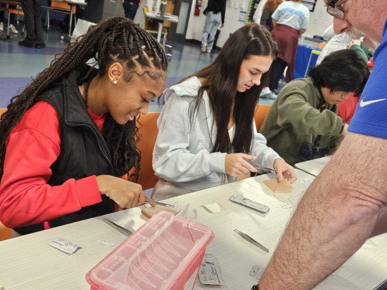 students practice suturing techniques at hs outreach event 