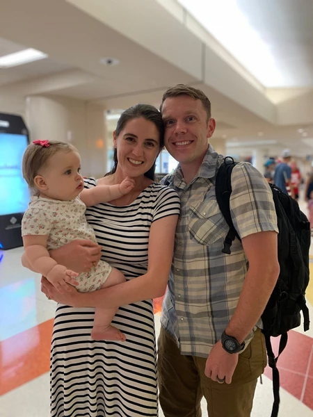 USAF Major, Dr. Chris Belcher at airport with partner and daughter