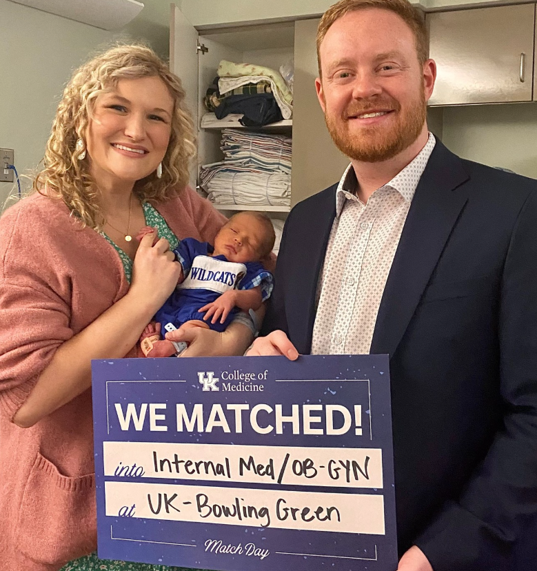 Abigail and Jason Hurt pose with "We Matched" sign, alongside their newborn son, Griffin