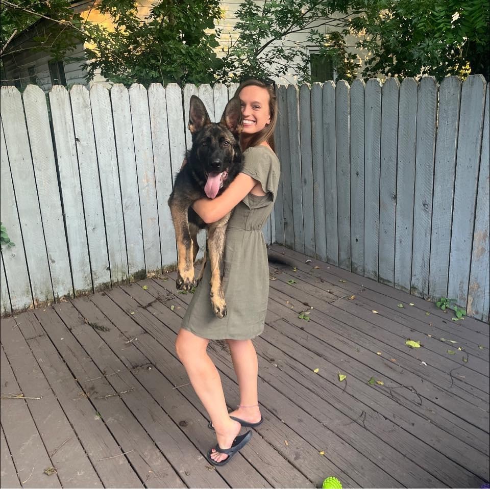 abby issacs holding her german shepherd dog