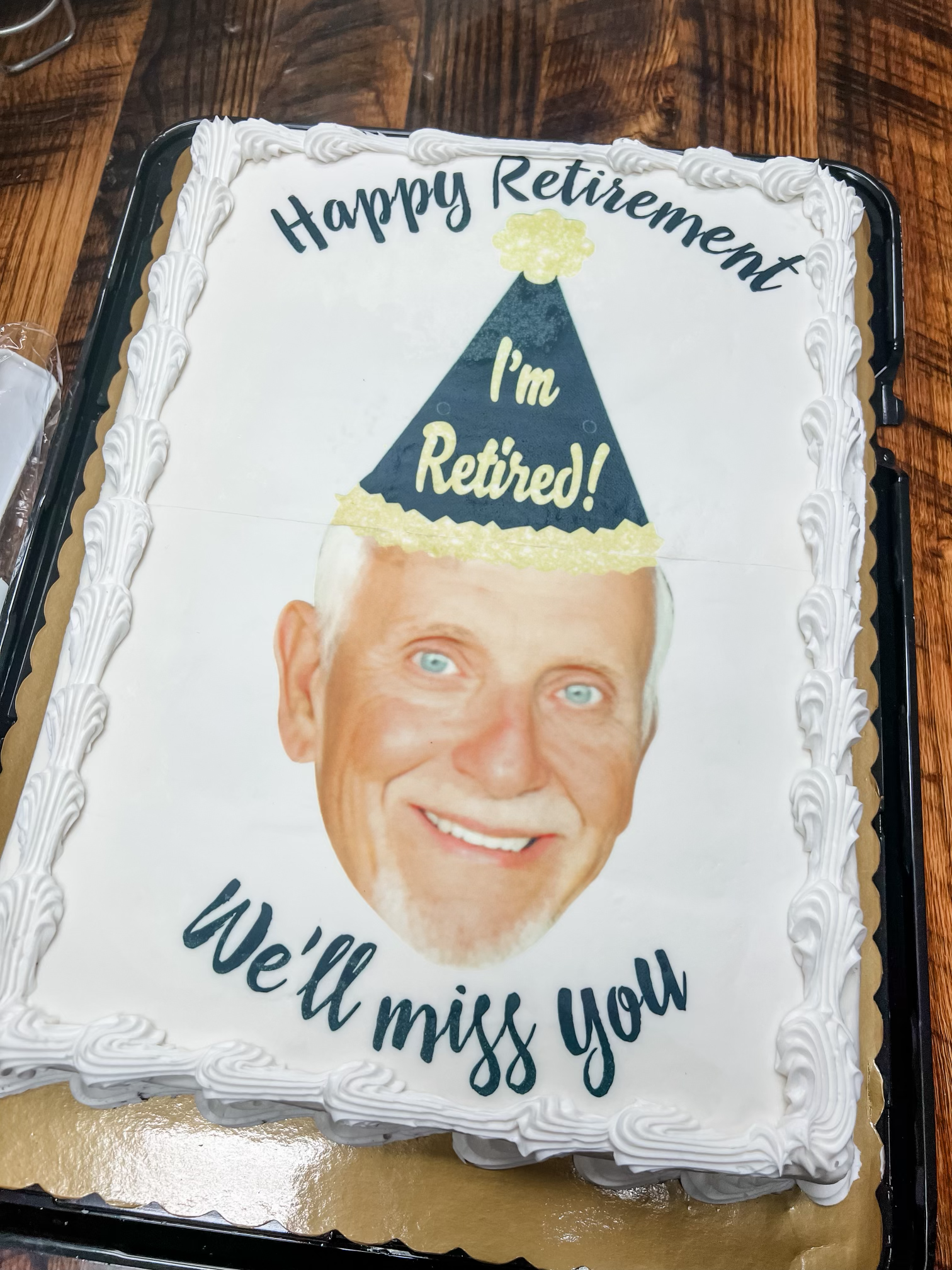 Dr. Campbell's retirement cake, featuring his portrait with a party hat. 