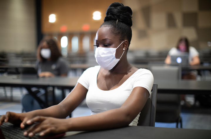 student in mask on computer in class.JPG