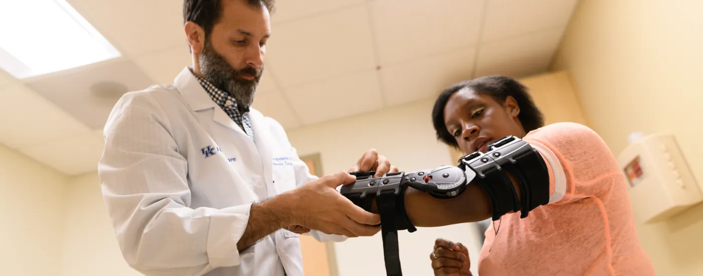 Doctor helping patient with an arm brace