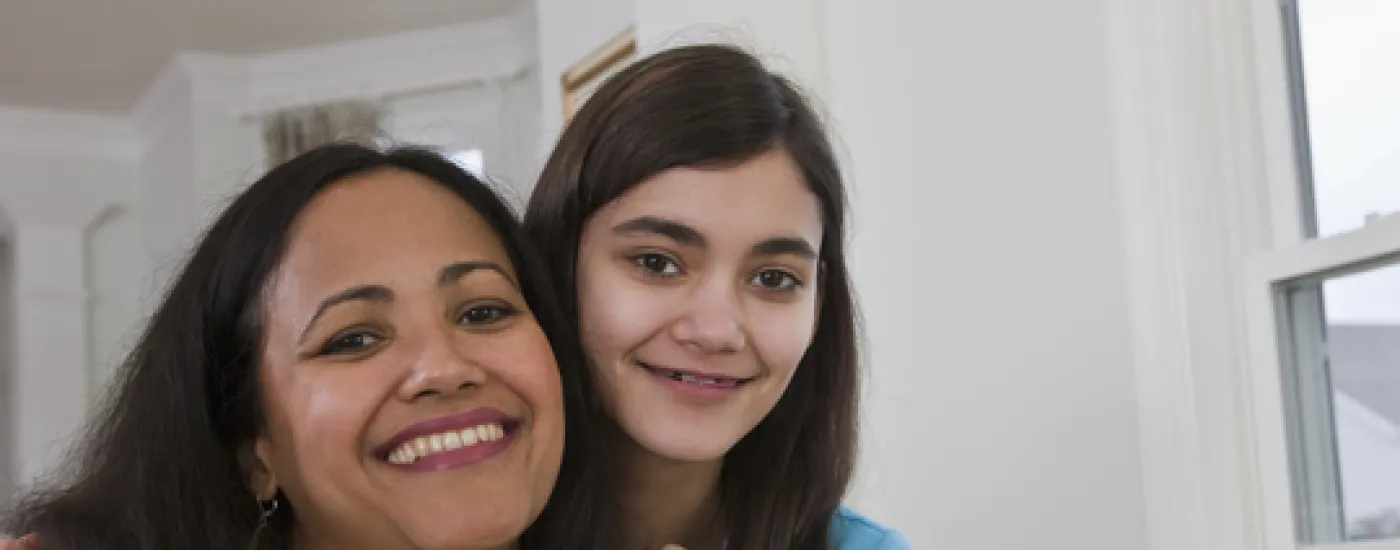 two people looking at camera and hugging