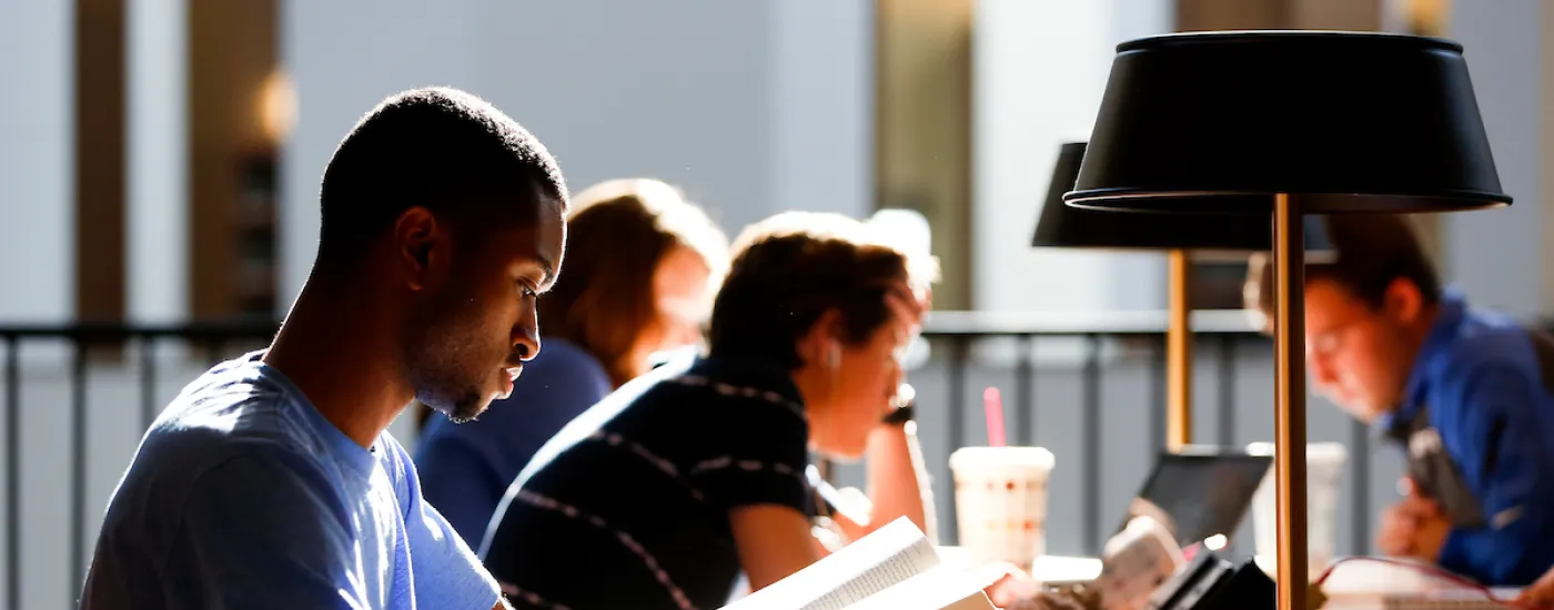 undergraduate student at library reading table