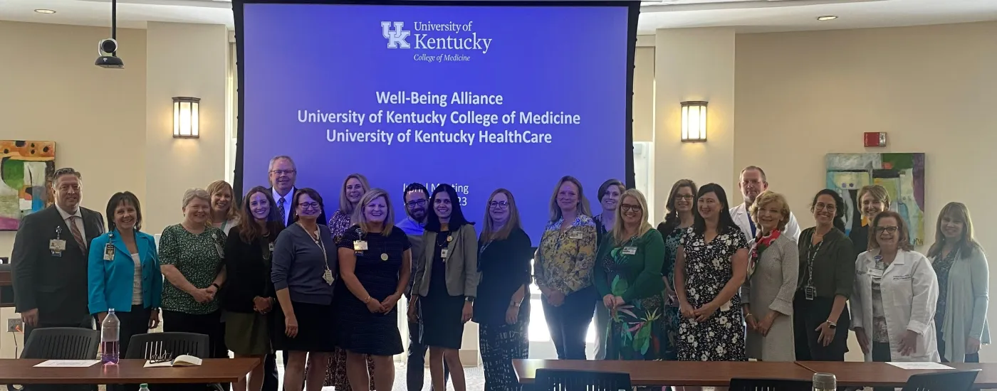 Group of UKCOM and UKHC committee members posing for a picture in front of a screen