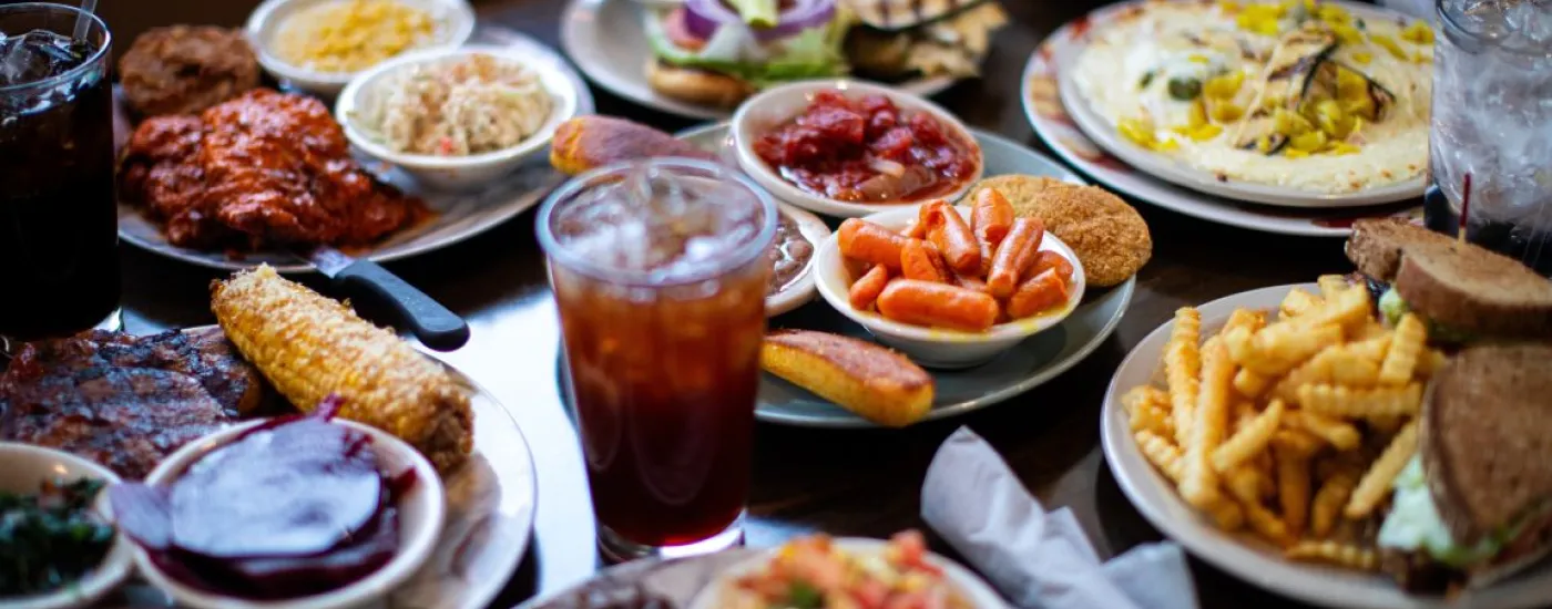 Closely cropped photo of several plates of food on a wooden table