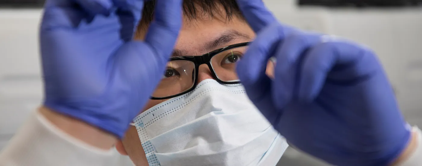 Close up of male scientist studying a slide. 