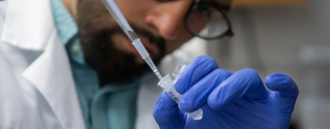 Tight shot of male scientist with dropper.