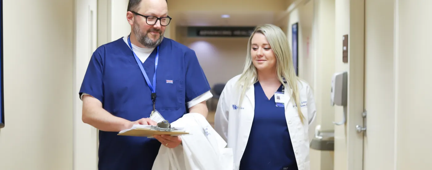 doctor and nurse walk down a hallway together