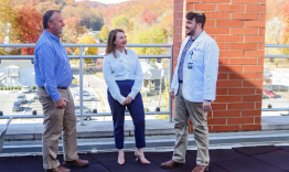 student affairs team member bodie stevens stands and talks to two medical students