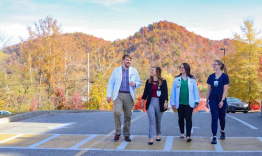 UK students from the Rural Physician Leadership Program walking out on a road in the mountains.
