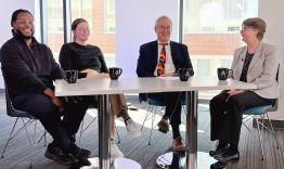 a panel of of 4 researchers at a table
