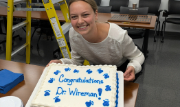 Olivia Wireman holding a cake that says "Congratulations Dr Wireman!"