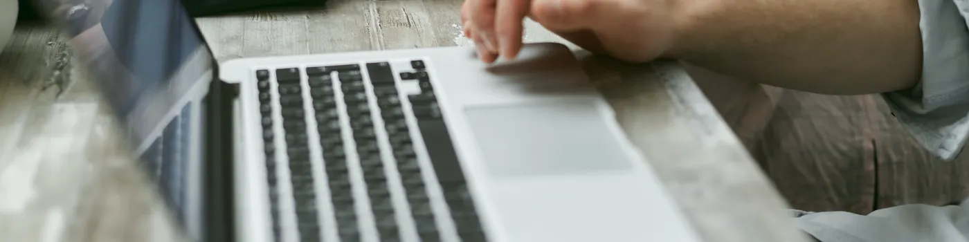 Individuals using laptops at a conference table.