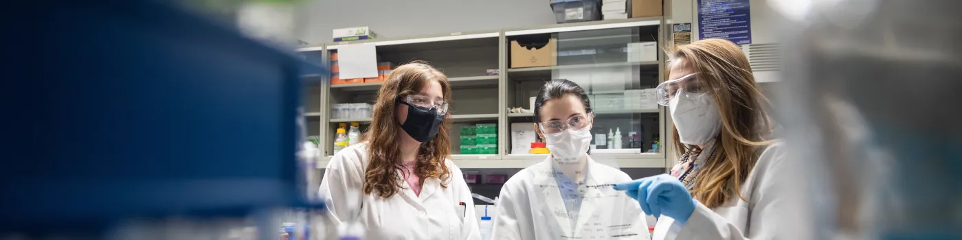 Faculty member in her lab with two learners