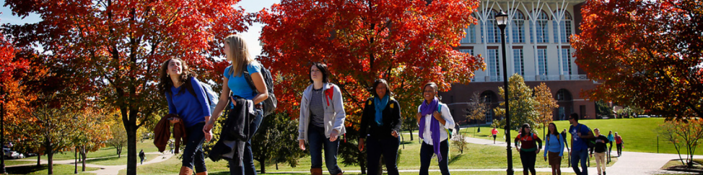 Kids walking across campus in fall.