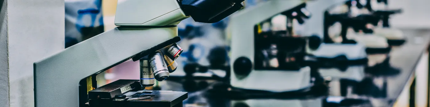 row of white microscopes on a black table