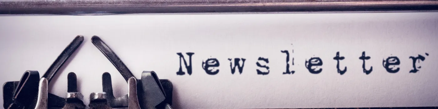 The word "Newsletter" typed onto a paper with a typewriter.