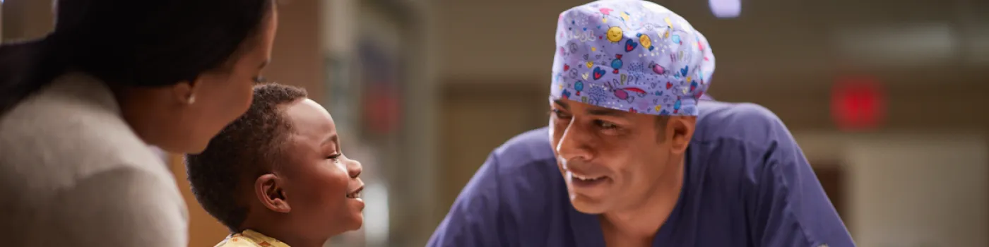 doctor talks with child patient and mother