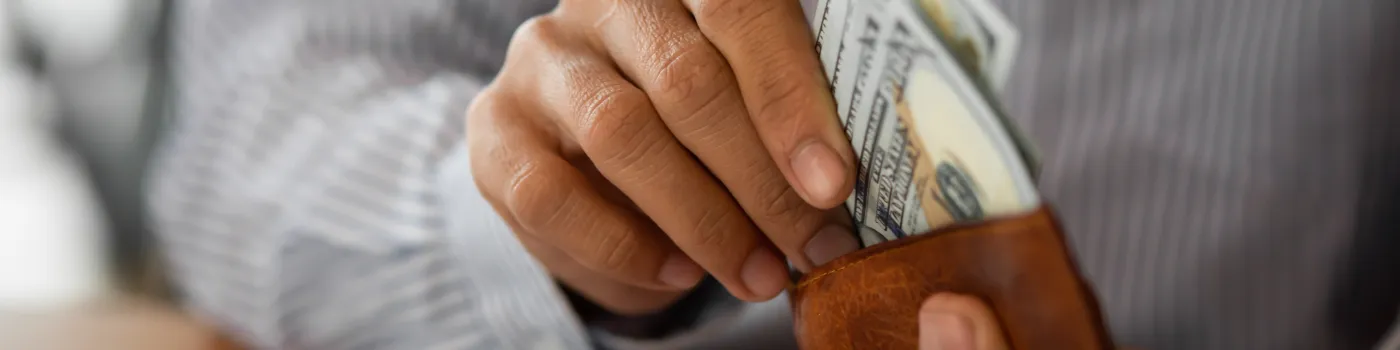 Man placing money in wallet